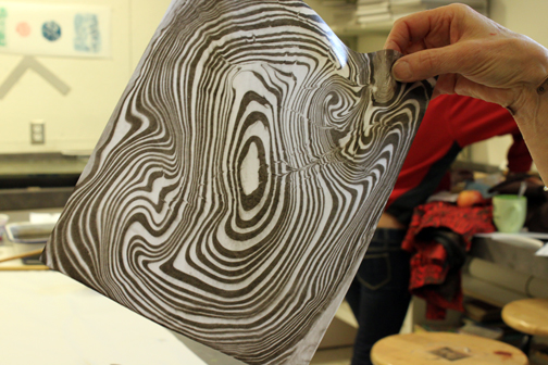 Suminagashi Marbling Class - pulling the paper off of the marbling bath to reveal the print