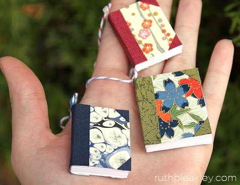 Handful of handmade book Christmas tree ornaments by Ruth Bleakley